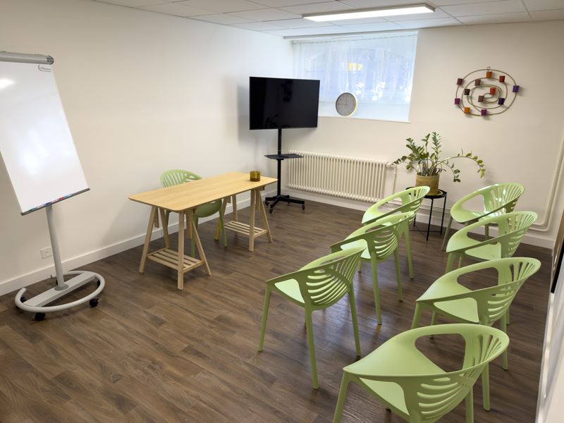 Espace de groupe : configuration conférence, rangées de chaises face à l'écran
