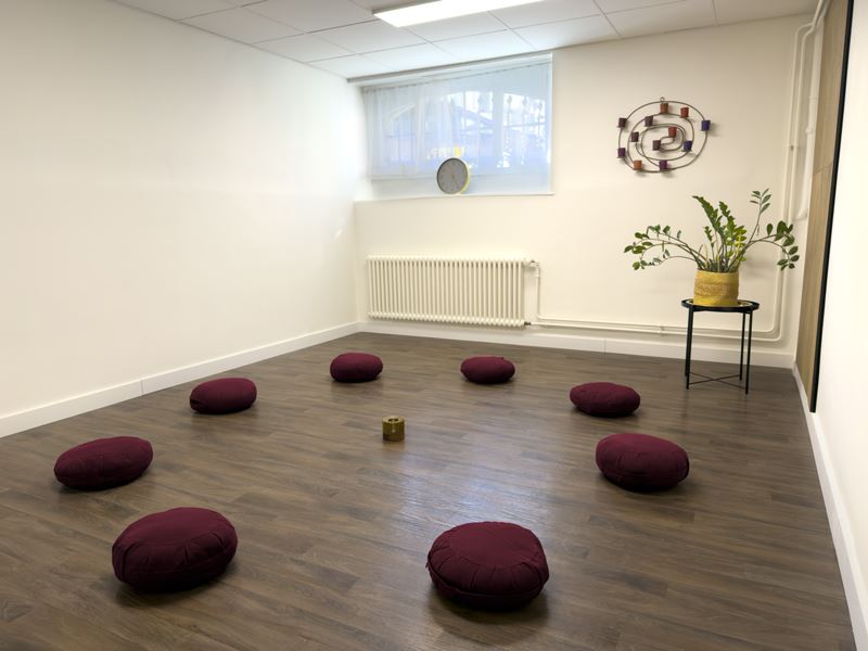 Espace de groupe : coussins de méditation disposés en cercle au sol