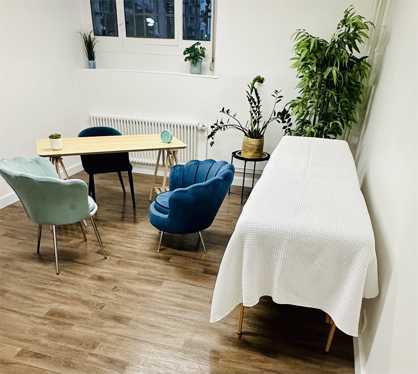 Salle Océan : vue d'ensemble avec la table de massage en bois et les fauteuils